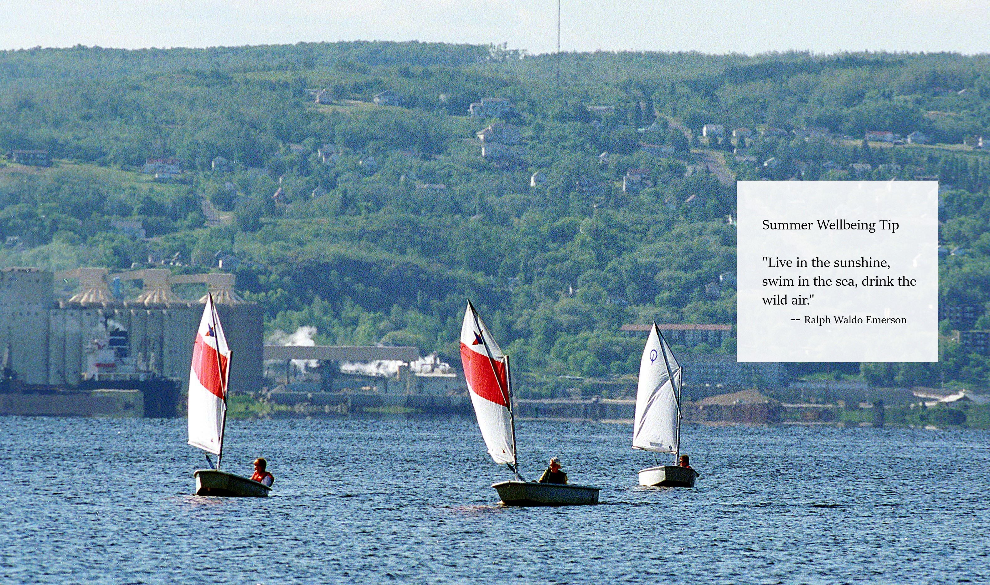 Three sailboats on Lake Superior with the Duluth, MN hillside in the background