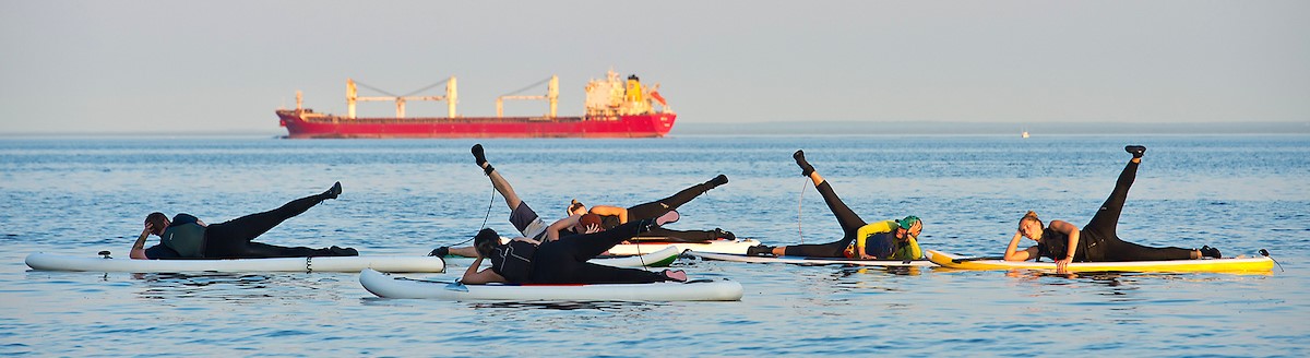 Yoga happening on stand up paddle boarding in Lake Superior